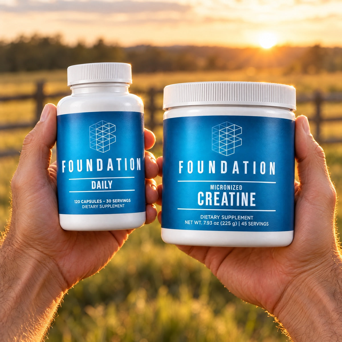 Two hands holding Foundation Daily and Foundation Creatine at sunset